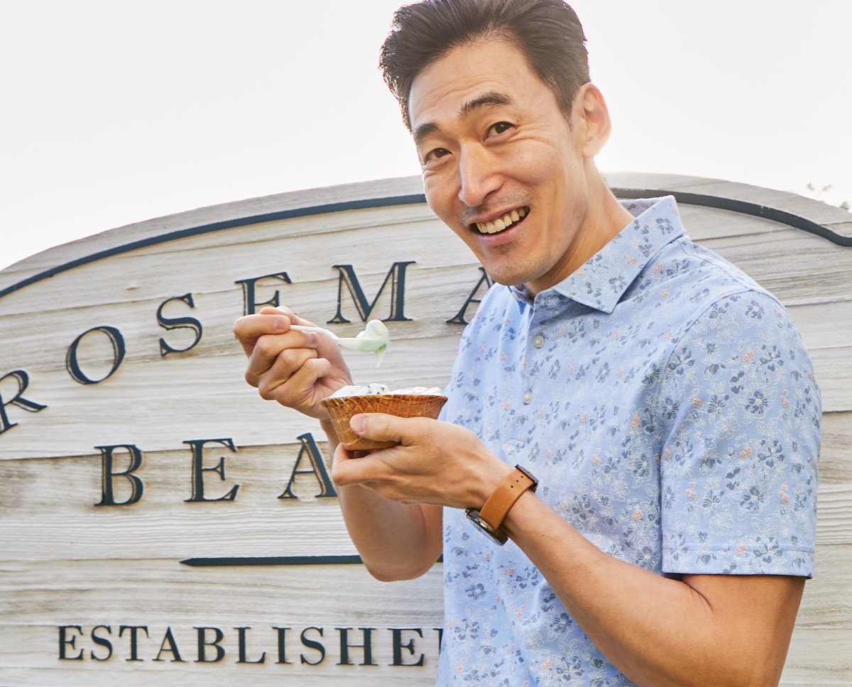 Man in light blue, floral polo eating ice cream